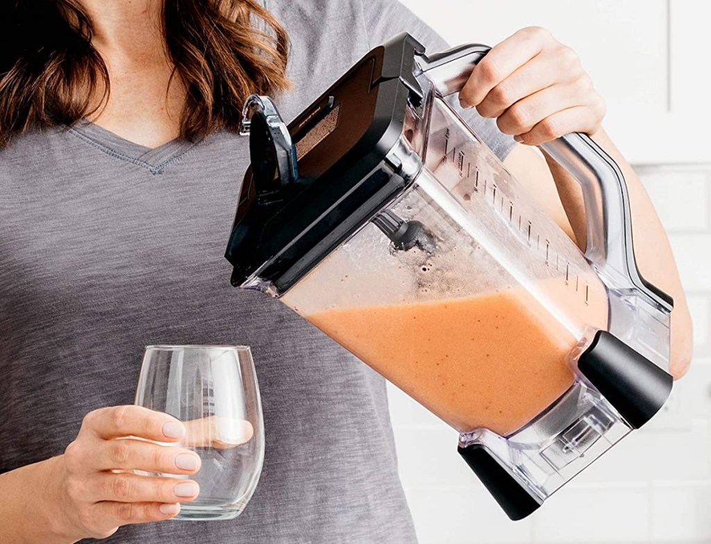 woman pouring a drink from a blender
