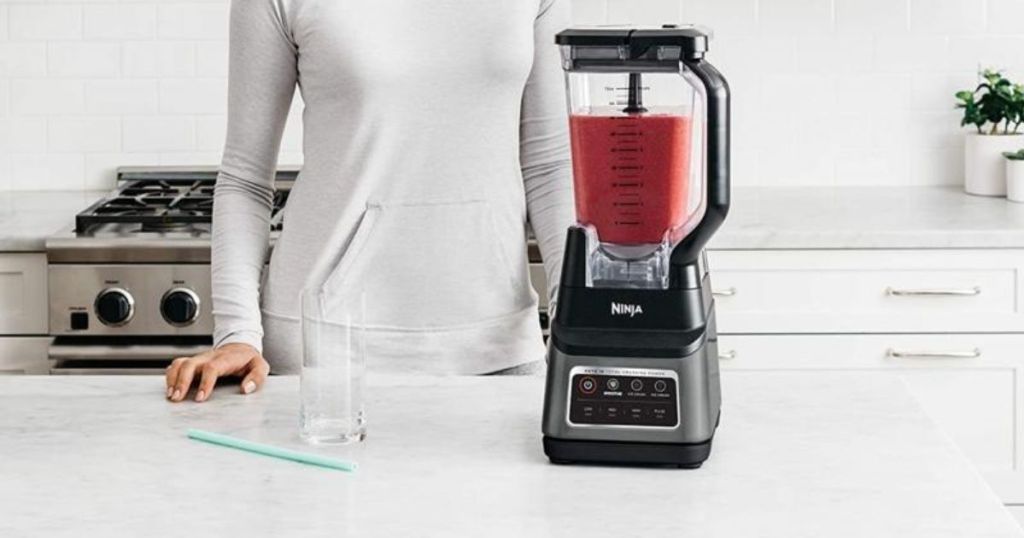 woman standing by a blender