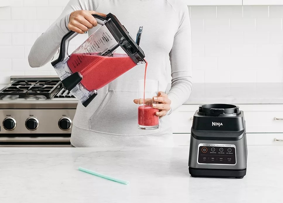 woman pouring a drink from a blender