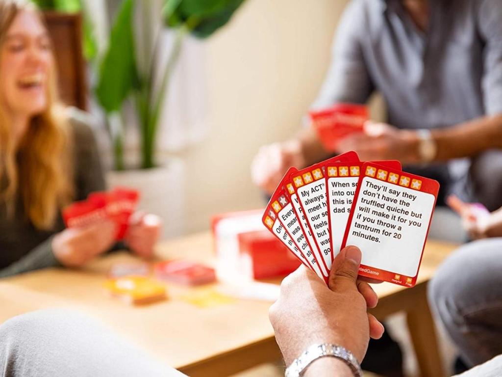 hand holding cards from over rated party game