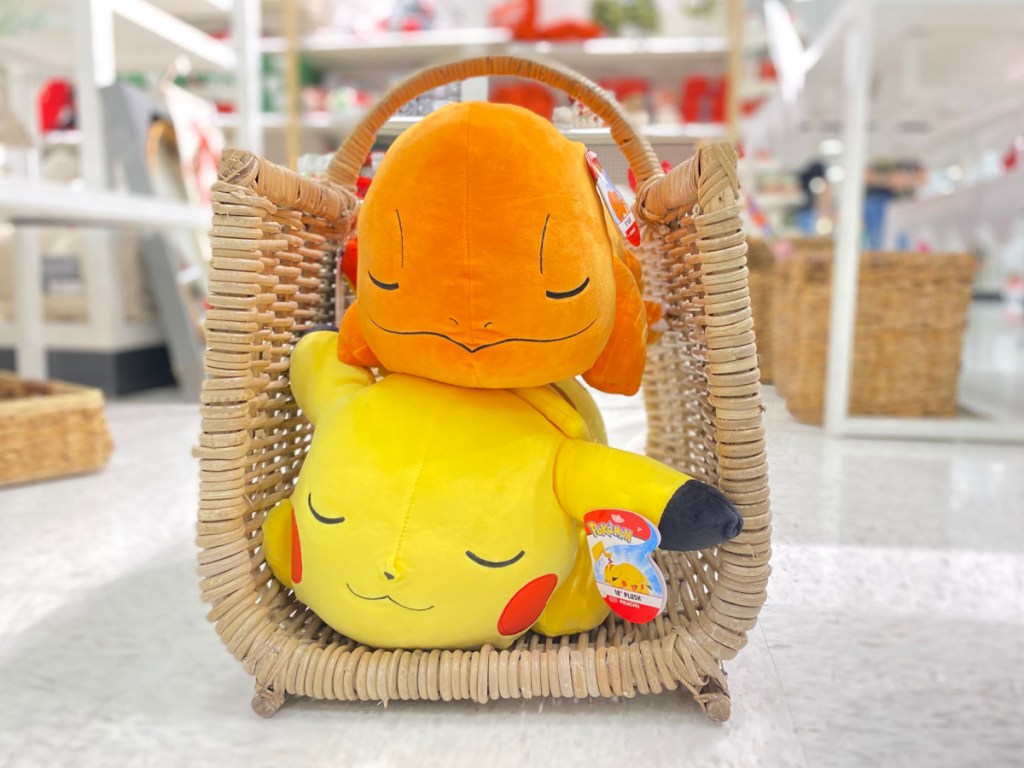 two Pokemon plush pillows in basket in store