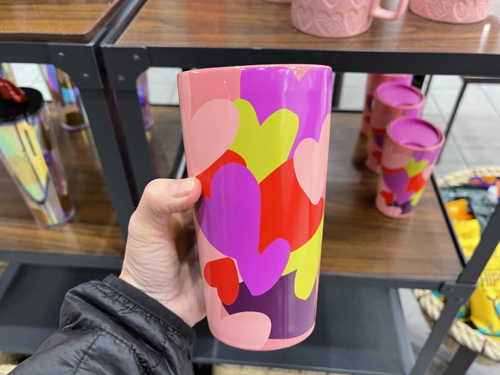 hand holding pink multi-colored Heart Tumbler in store