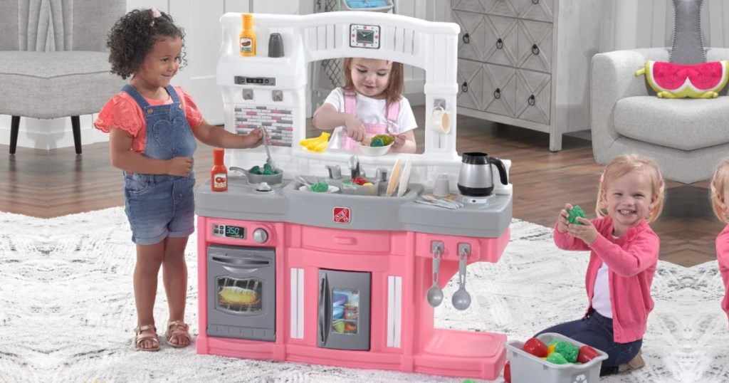 3 little girls playing with play kitchen