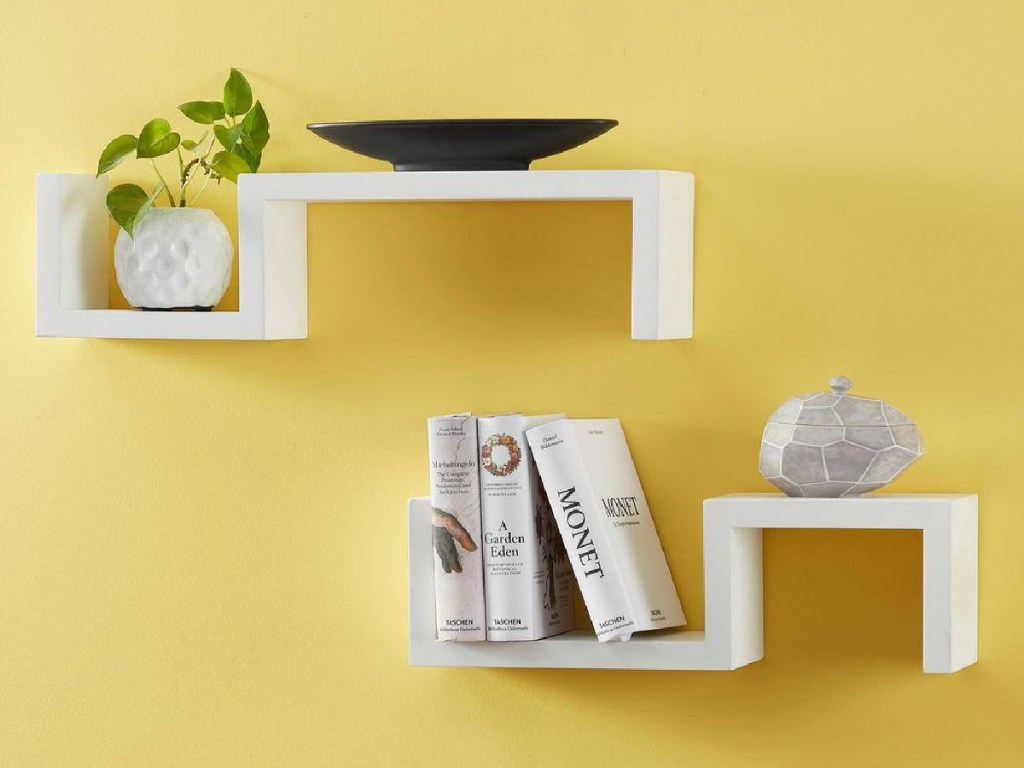 yellow wall with 2 white wood shelves