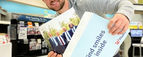 man holding 8x10 photo in walgreens