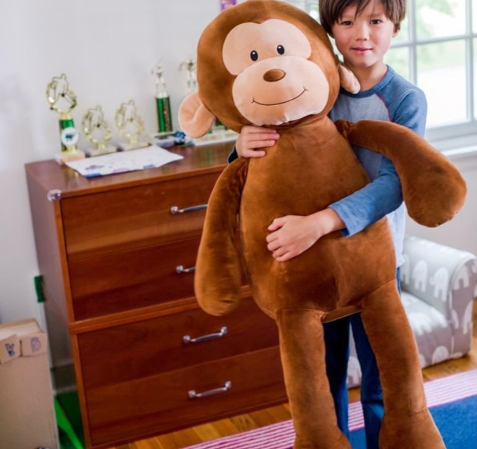 Little boy holding Wellobeez Monkey Plush