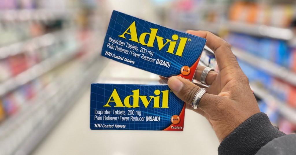 woman holding up 2 boxes of advil pain relief tablets