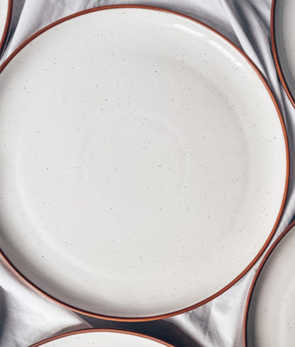 close up of white dinner plates on white table cloth 