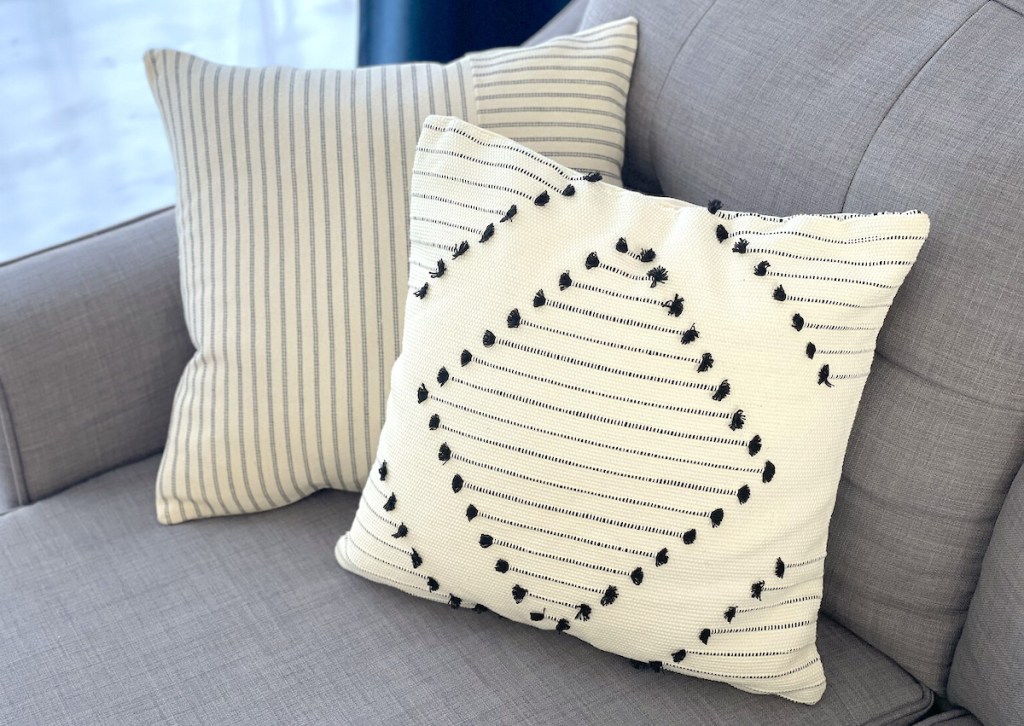 two cream colored throw pillows on gray couch