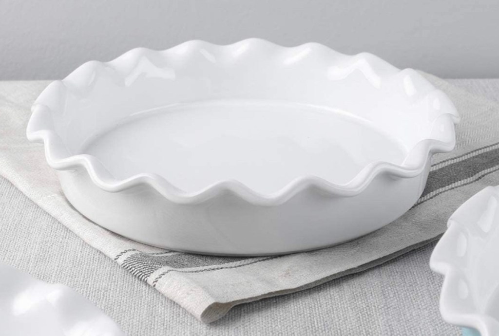 empty white pie dish on table sitting on gray linen napkin 