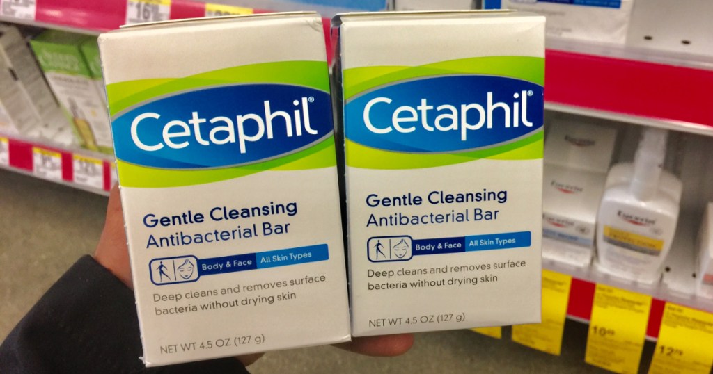 hand holding 2 packages containing Cetaphil brand soap bars in store