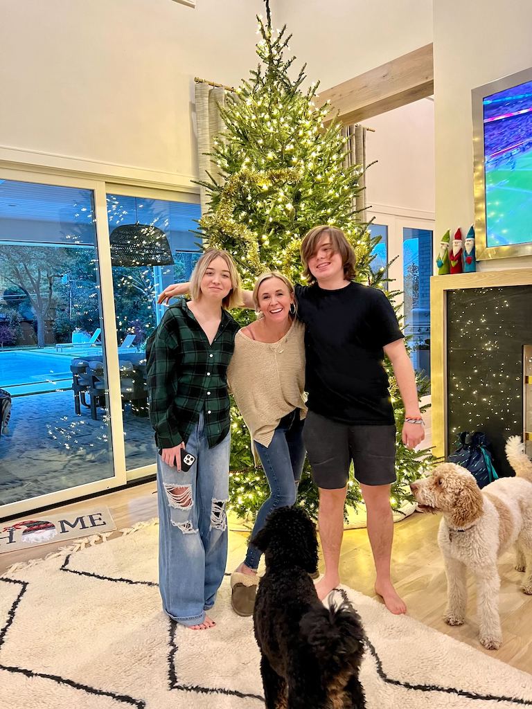 woman with big kids in front of christmas tree
