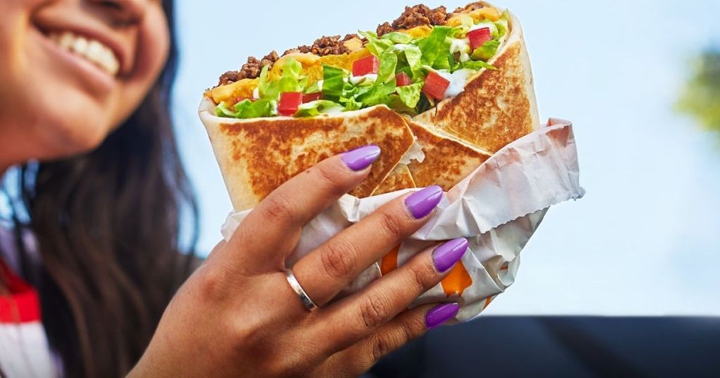 hand holding a Crunchwrap supreme from taco bell