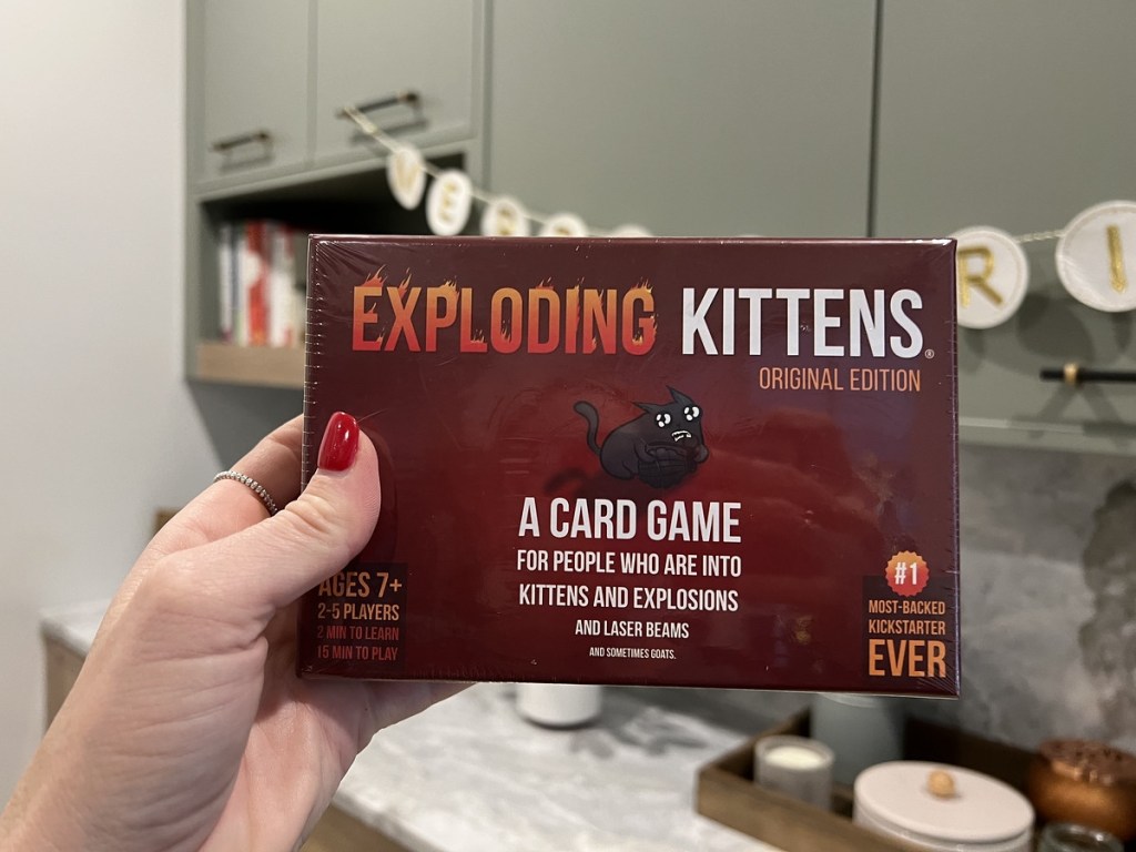 holding Exploding Kittens card game