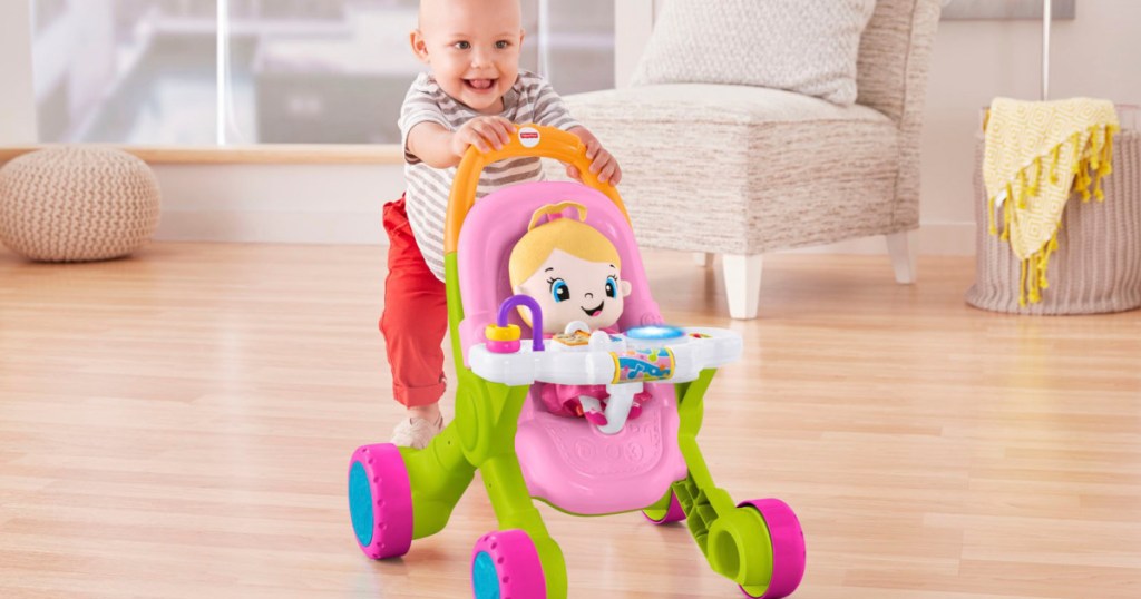 baby pushing a fisher price stroller with a baby doll