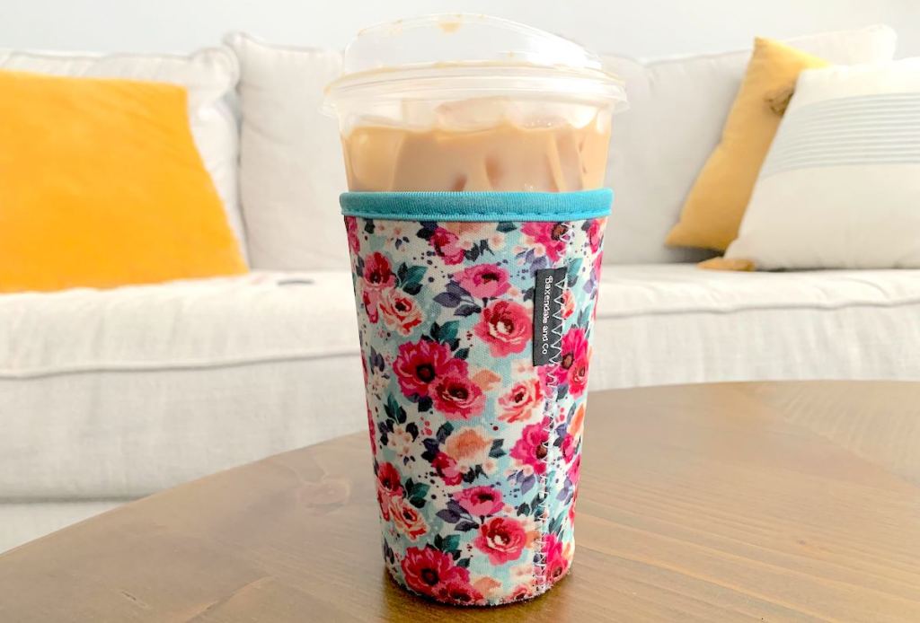 tall iced coffee in plastic cup with floral sleeve on outside