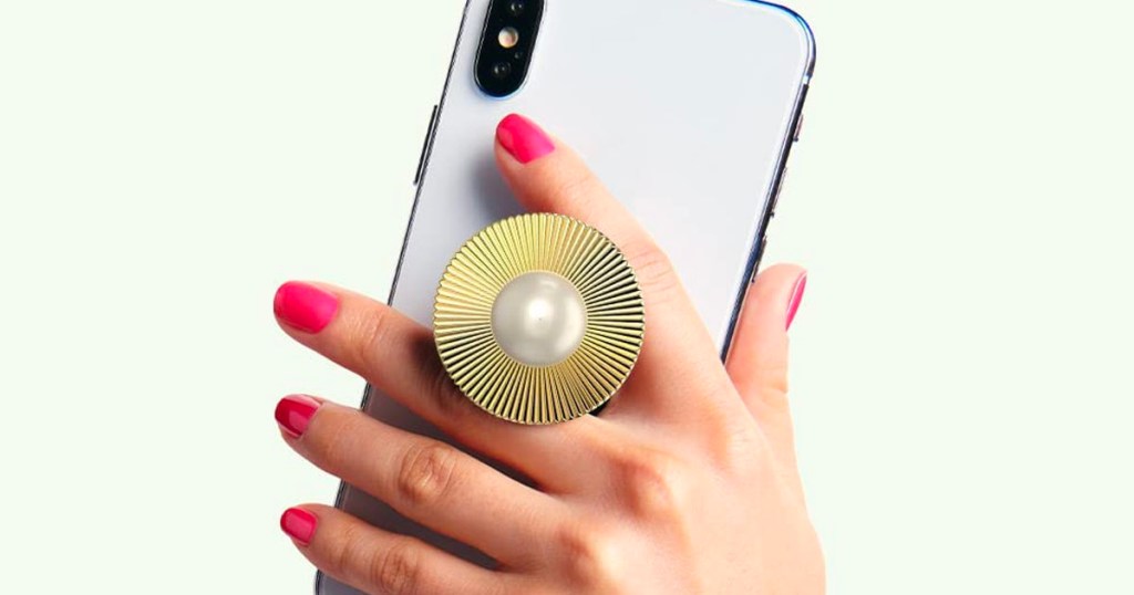 hand holding phone with gold popsocket