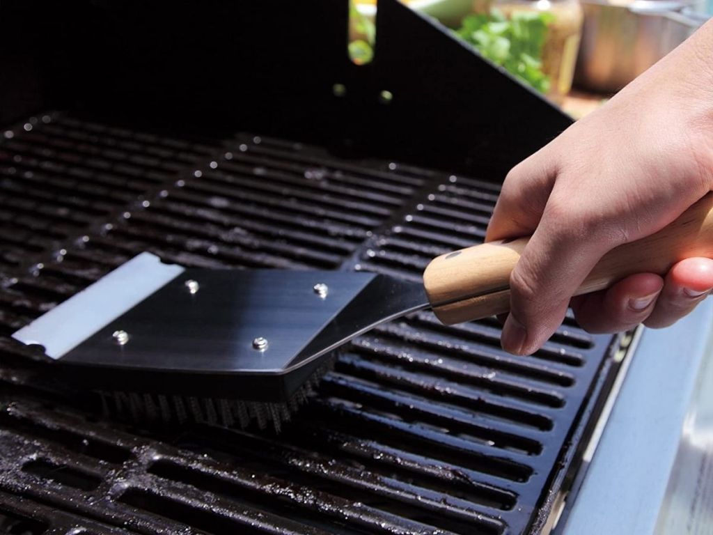 preson using grill brush on grill grate