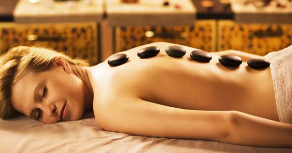 woman laying on a table getting a hot stone massage