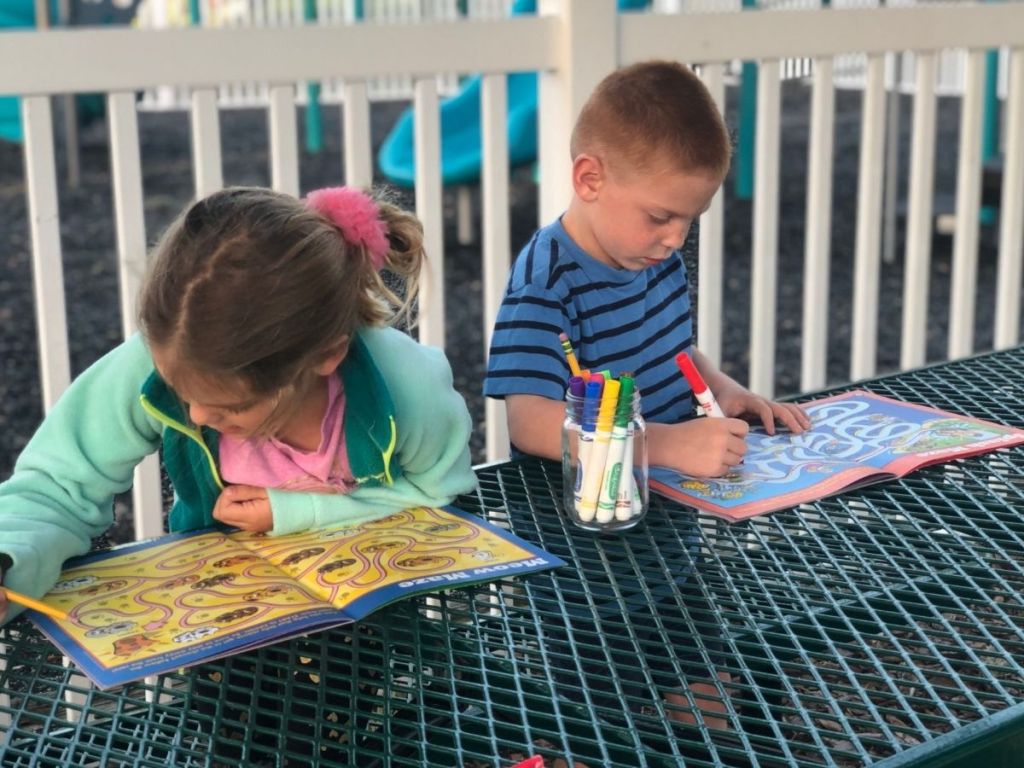 kids sitting at park table doing Highlights puzzles