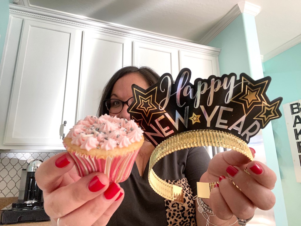 holding cupcake and Happy New Year headband 