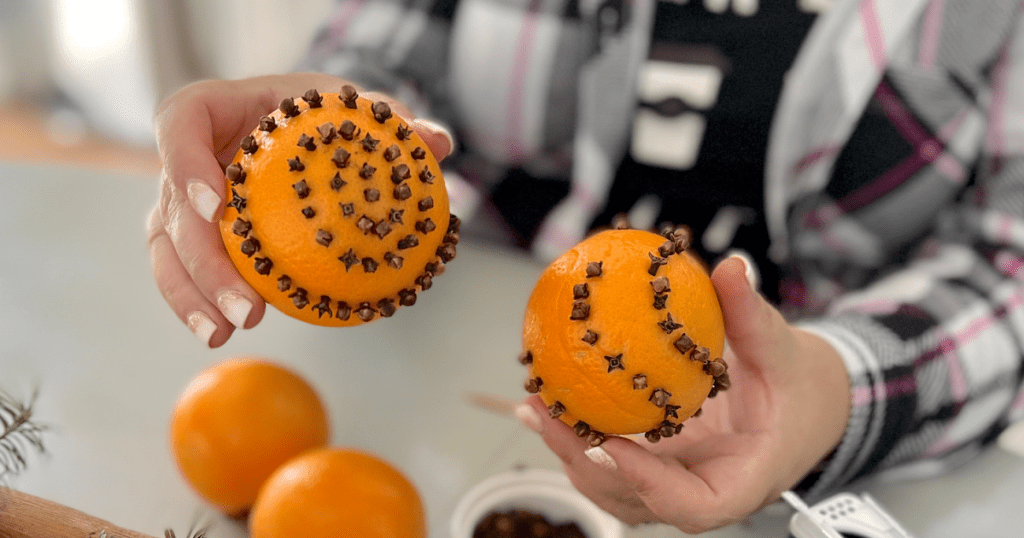 holding orange and clove pomander balls 