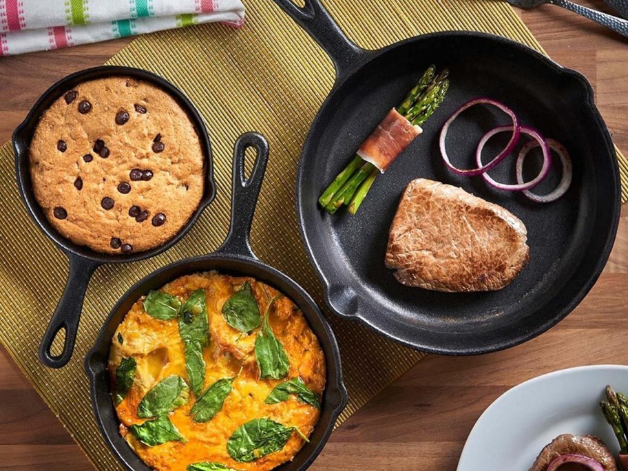 3 cast iron skillets on table with cookies and food 