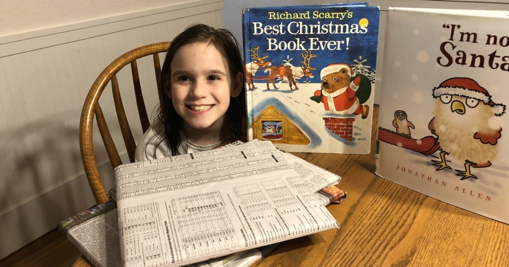 girl with newspaper wrapping and library christmas books