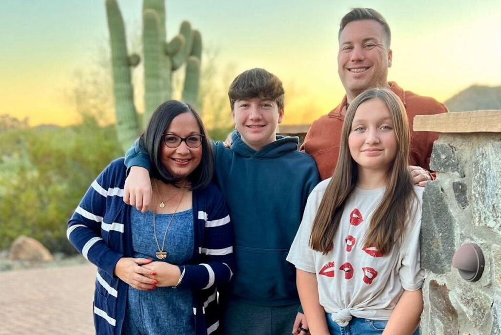 family standing together outside in desert sunset