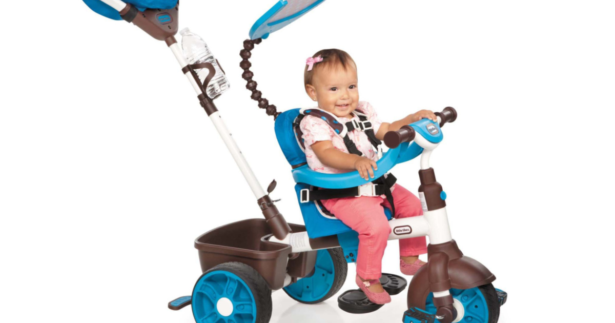 young girl sitting in a little tikes trike