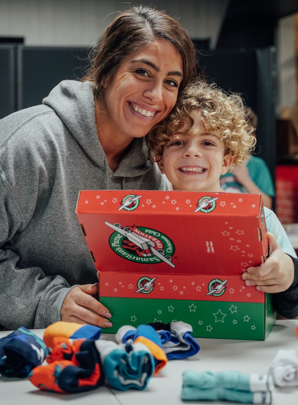 woman and son packing up operation christmas child boxes