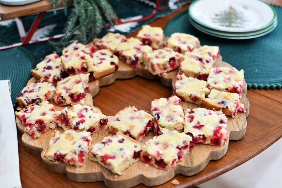 placing cranberry cake on a wood threshold wreath platter 