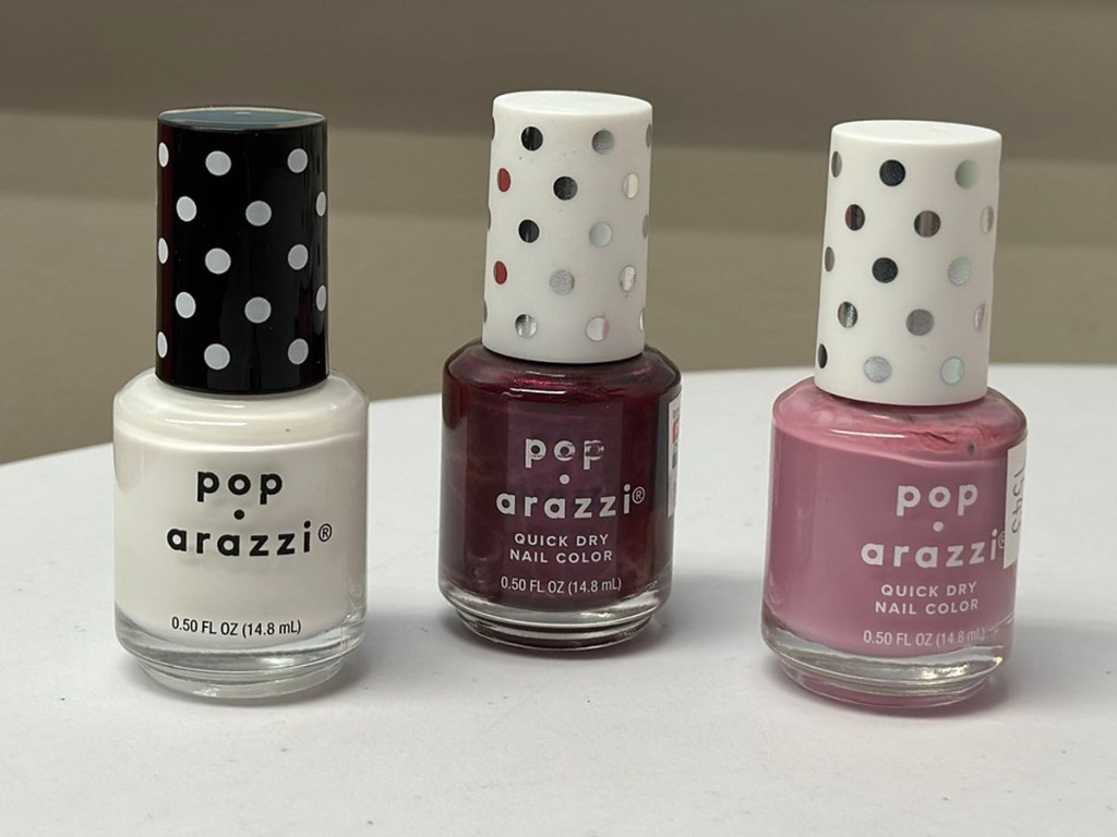 three poparazzi nail polish on table