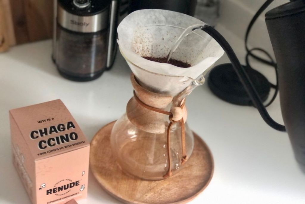 making pour-over coffee beside a pack of Renude mushroom coffee mix