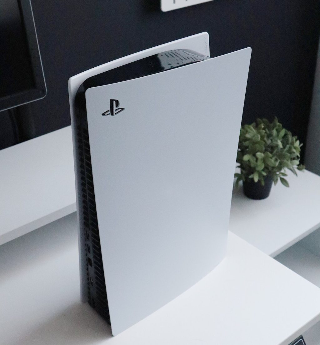 close up of white and black ps5 gaming console on white table