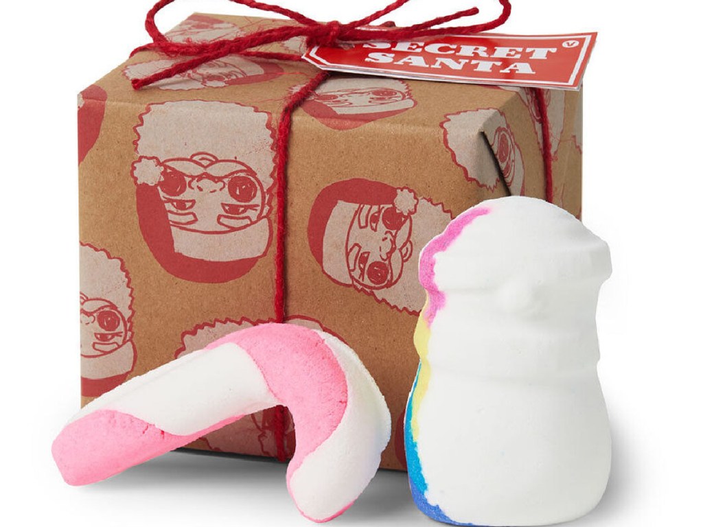 wrapped box with candy cane and snow man shaped bath bombs in front of it.