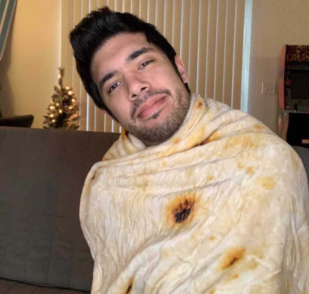 man smiling wrapped in tortilla shell blanket