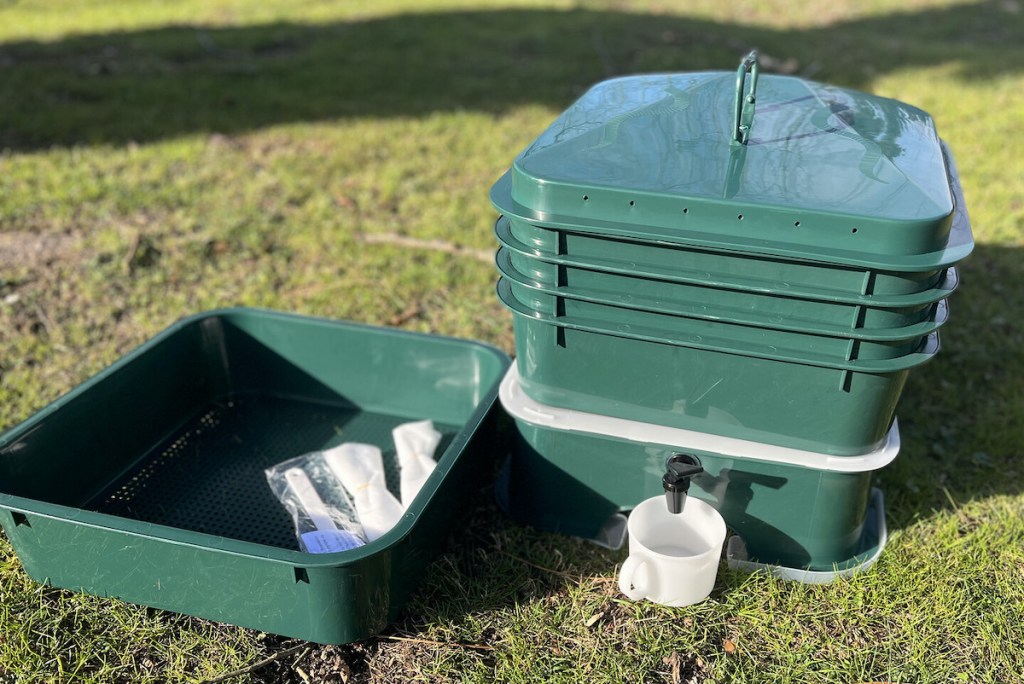 green worm compost bin on grass outside