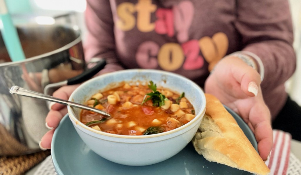 woman holding a bowl of minestrone soup