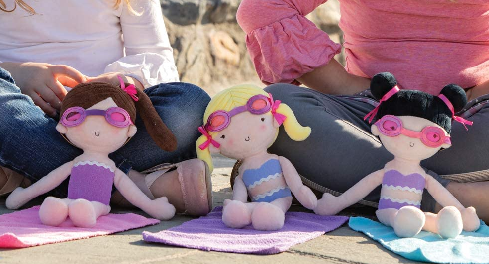 three dolls sitting on towels