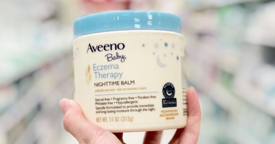 hand holding a container of Aveeno Baby Eczema Therapy