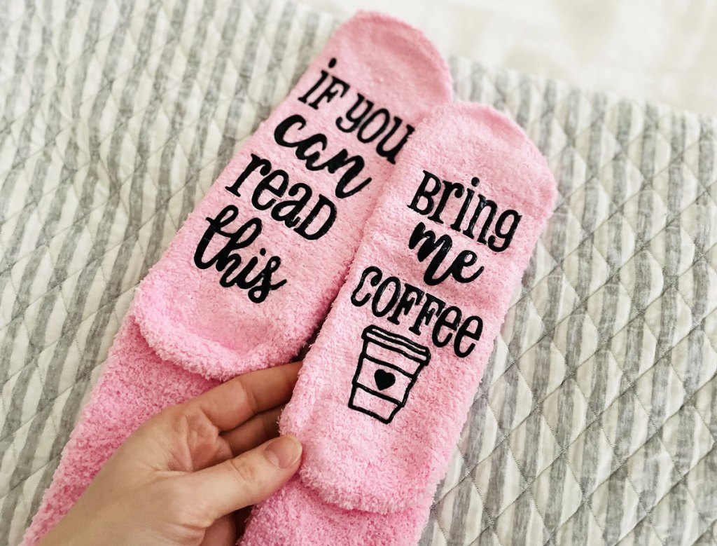 holding pink pair of fuzzy socks