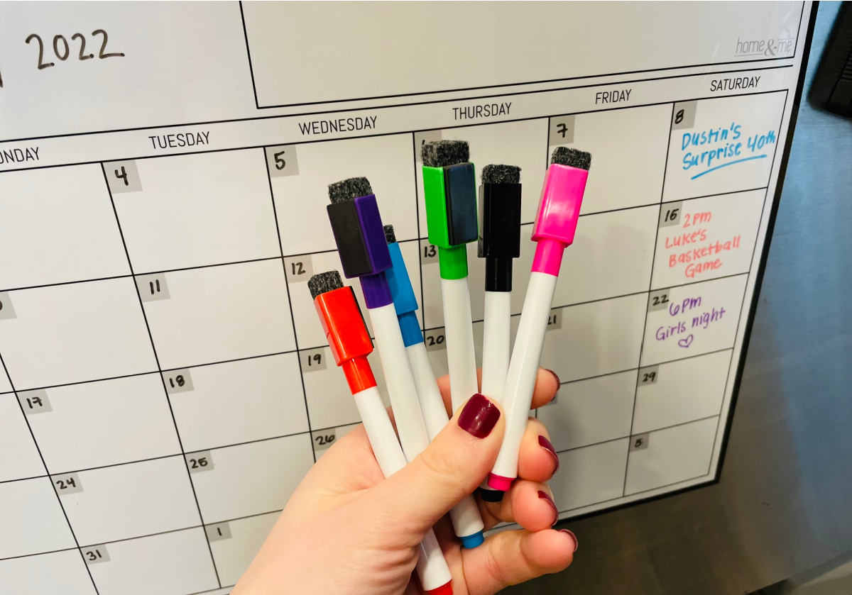 hand holding dry erase markers