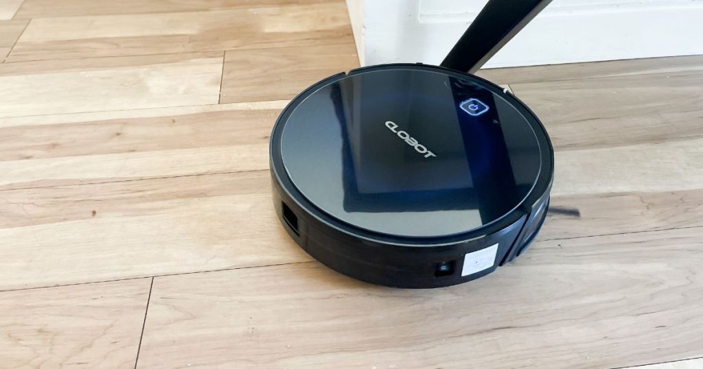 black robotic vacuum on wood floor