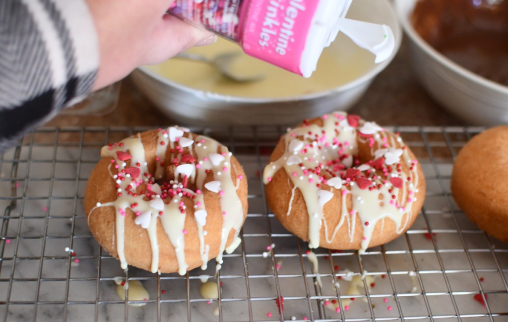 Applying sprinkles to doughnuts 