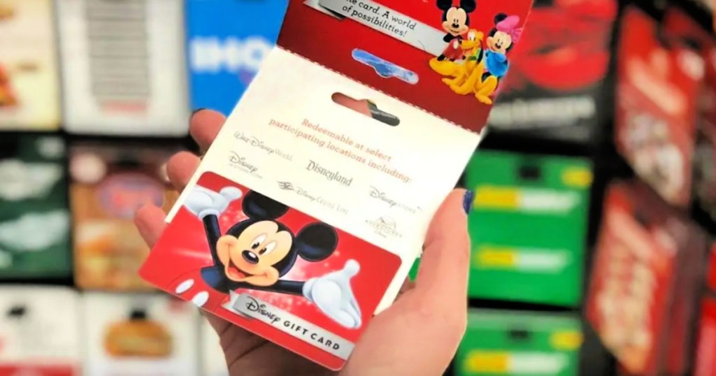 person holding disney gift card in store