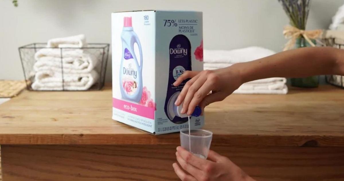 someone pouring downy fabric softener into cup