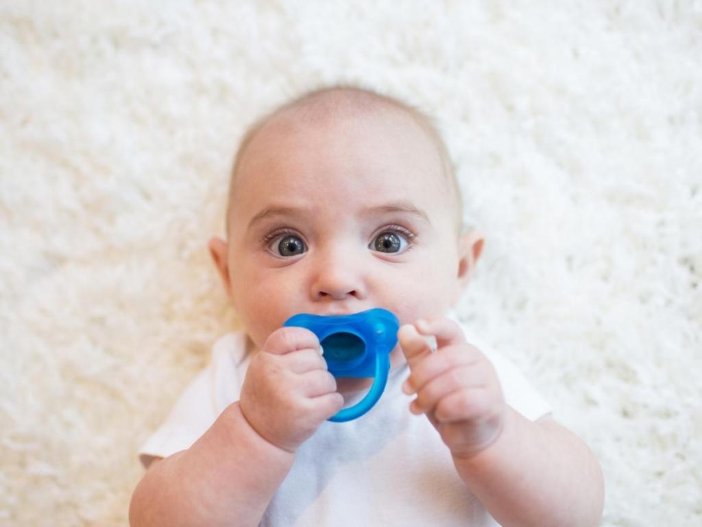 baby with dr. brown's silicone pacifier in blue
