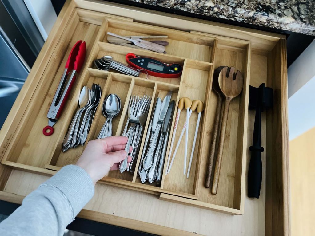 hand holding flatware in an organizer