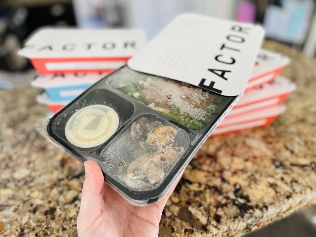 hand sliding out frozen tray of food from Factor box
